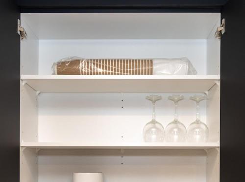 a white shelf with wine glasses and a bottle at GoodVibes in Calgary