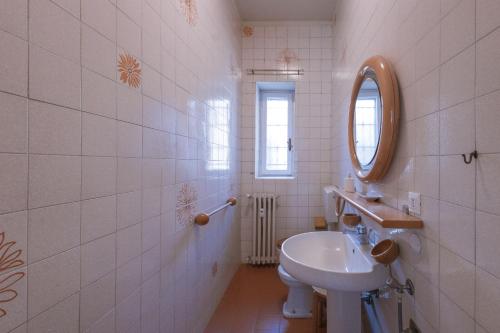 un bagno bianco con lavandino e specchio di Golf house ad Alessandria