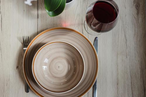 a bowl on a table with a cup and a fork at Das InnSight Appartementhaus - Appartements mit Küchen für Lang und Kurzzeitaufenthalte in Passau