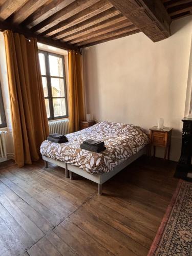 une chambre avec un lit dans une pièce avec des fenêtres dans l'établissement Maison intra muros, à Langres