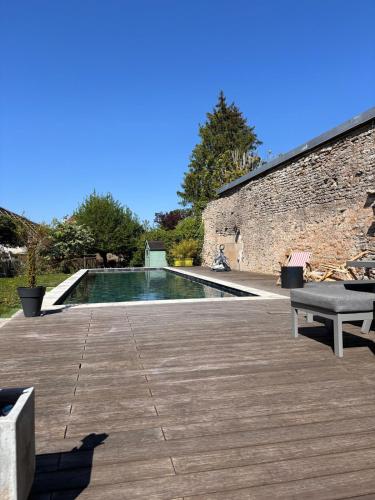 une piscine avec un banc sur une terrasse en bois dans l'établissement Maison intra muros, à Langres