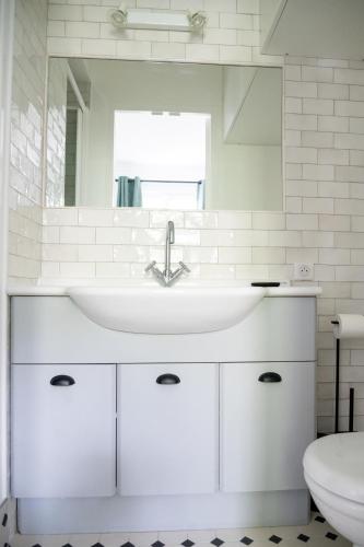une salle de bain blanche avec un lavabo et des toilettes dans l'établissement Cosy suite with a terrasse in a calm area, à Paris