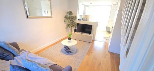 a living room with a couch and a tv at 2 Bed House near Canary Wharf in London