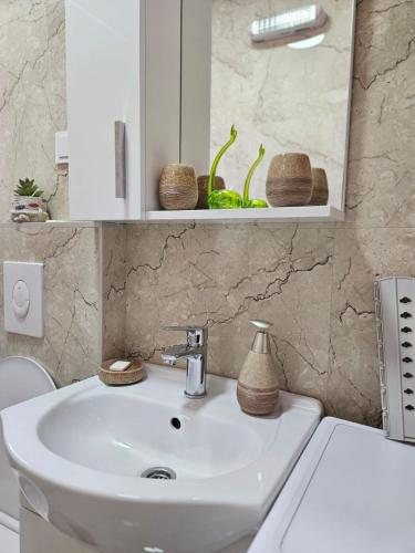 a bathroom with a white sink and a mirror at Lutovac Apartmani in Kotor