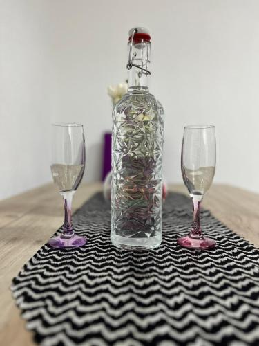 a bottle of wine and two wine glasses on a table at Lutovac Apartmani in Kotor