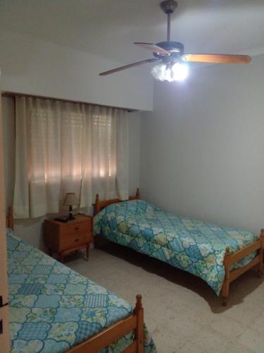 a bedroom with two beds and a ceiling fan at LOS CACTUS in Tandil