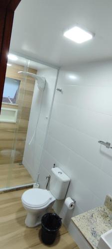 a white bathroom with a toilet and a sink at Pedaço da quinta in Teresópolis