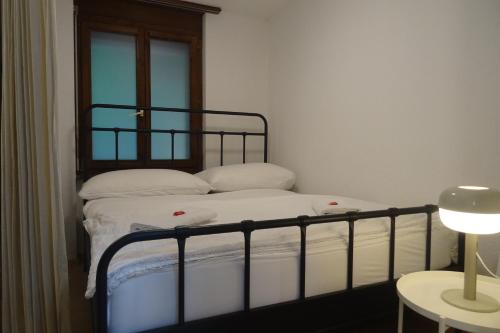 une chambre avec un lit avec des draps blancs et une fenêtre dans l'établissement Aare Studio15, à Interlaken