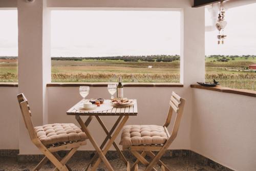 ein Tisch und Stühle in einem Zimmer mit Fenster in der Unterkunft Casa Coração Alentejano- Casas com EnCanto in Reguengos de Monsaraz