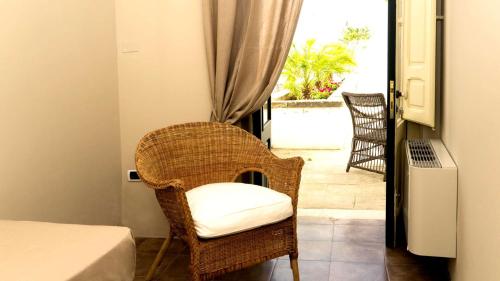 a room with a chair and a bed and a window at Don Alfonso Dimora D'epoca in Racale