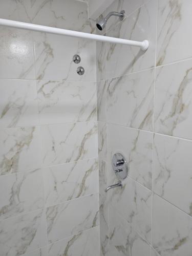 a bathroom with a shower with white marble tiles at Alquiler por dia Flor de Loto in Chos Malal