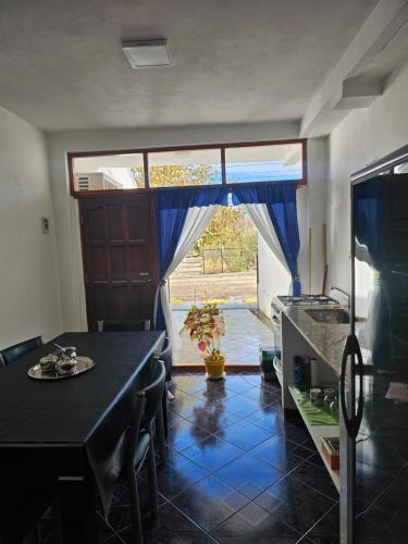 a kitchen with a table and a blue tile floor at Alquiler por dia Flor de Loto in Chos Malal