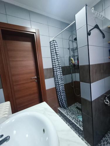 a bathroom with a shower and a sink and a tub at Urban Home in Sarajevo