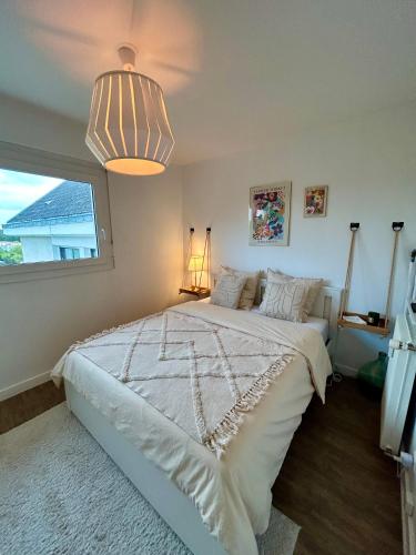 une chambre avec un grand lit blanc et une fenêtre dans l'établissement Élégant cocon - Saint-Rémi, à Reims