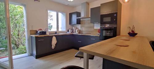 une cuisine avec une table en bois et une grande fenêtre dans l'établissement Maison GAILLAC, à Gaillac