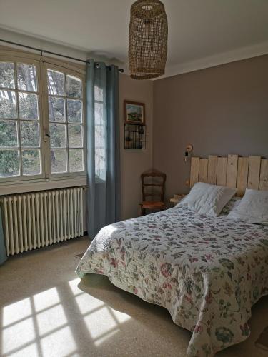 - une chambre avec un lit avec une couette et 2 fenêtres dans l'établissement Magnifique villa avec piscine, à La Bouilladisse