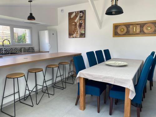 eine Küche mit einem Tisch und blauen Stühlen in der Unterkunft Villa La Glycine in Saint-Avé