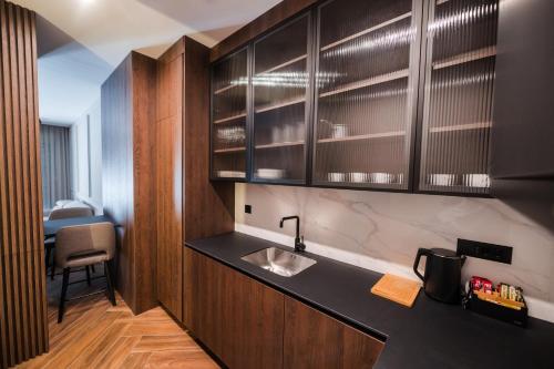 a kitchen with wooden cabinets and a sink at Ideal Apartments in Banja Luka