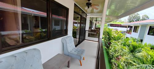 a porch with two chairs and some plants at Ballena Rey Hotel in Uvita