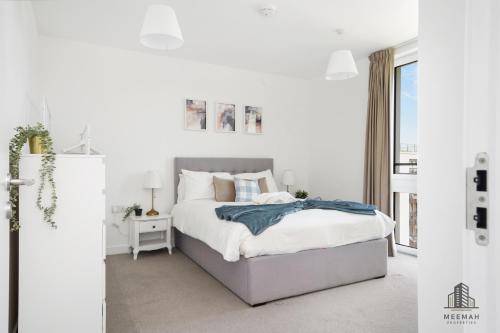 a white bedroom with a bed and a window at Modern 3 bedroom - Olympic Park - E20 Stratford in London