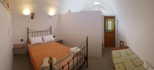 a bedroom with a bed with an orange comforter at Corones House in Frilingiánika