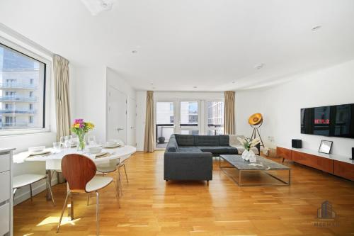 a living room with a couch and a table at Modern 3 bedroom - Olympic Park - E20 Stratford in London