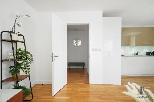 a living room with white walls and a wooden floor at Modern 3 bedroom - Olympic Park - E20 Stratford in London