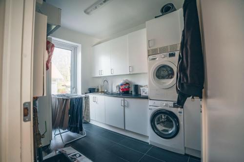 a kitchen with a washer and a washing machine at Exklusivt boende med pool & öppen spis in Färjstaden