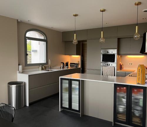 une cuisine avec des appareils en acier inoxydable et un comptoir dans l'établissement Villa Médaillon, Sur la mer - Mesnil Val Plage, à Criel-sur-Mer