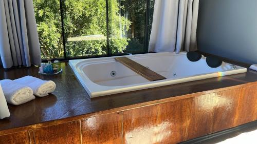 a bath tub in a bathroom with a window at Rota do Engawno in Barracão