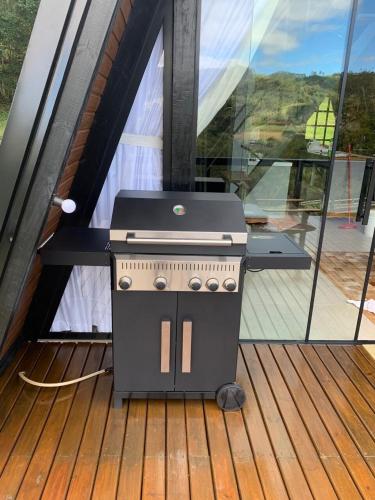 a grill sitting on a deck in a house at Rota do Engawno in Barracão
