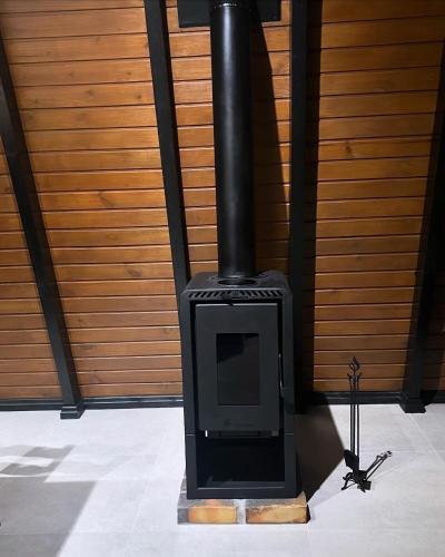 a black stove with a tv in a room at Rota do Engawno in Barracão