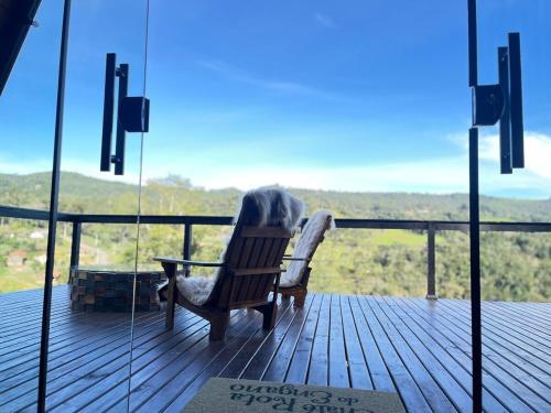 a rocking chair sitting on a deck with a view at Rota do Engawno in Barracão