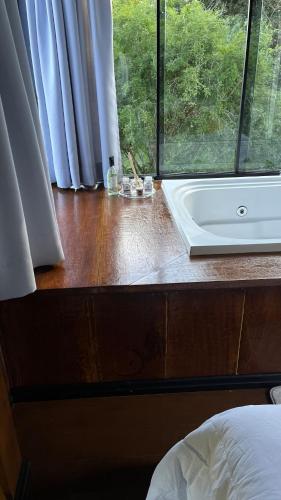 a bathroom with a bath tub and a window at Rota do Engawno in Barracão