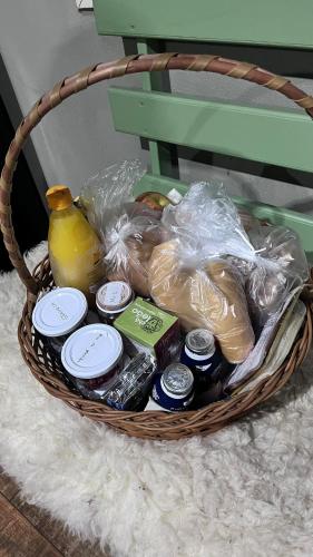 a basket filled with food and drinks on a rug at Rota do Engawno in Barracão