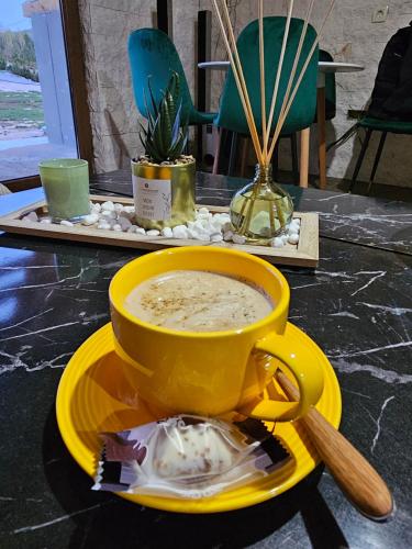 a yellow cup of soup on a yellow plate on a table at Moj raj Zabljak in Borje