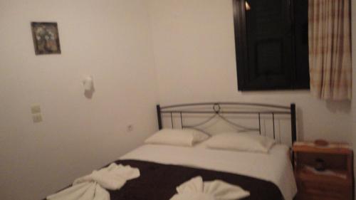a bedroom with a bed with white pillows at Archontika Apartments in Kerames