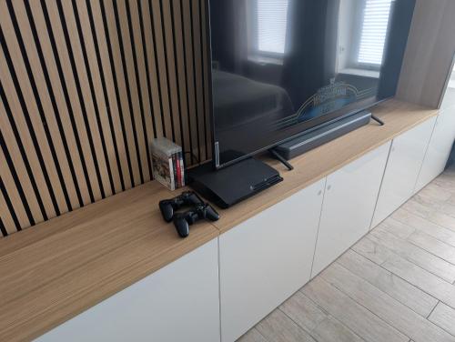 a video game controller sitting on a counter with a television at Helles Studio mit Arbeitsplatz und Balkon in Chemnitz