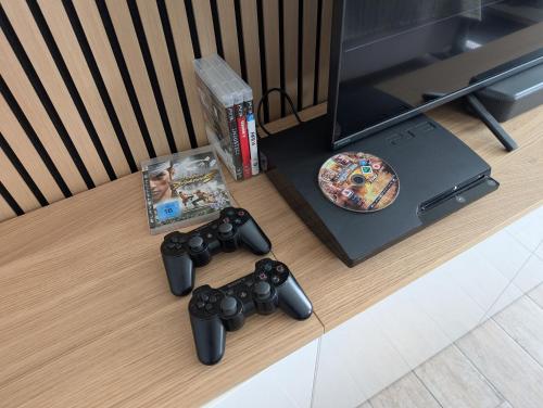 a table with a video game controller and a dvd at Helles Studio mit Arbeitsplatz und Balkon in Chemnitz