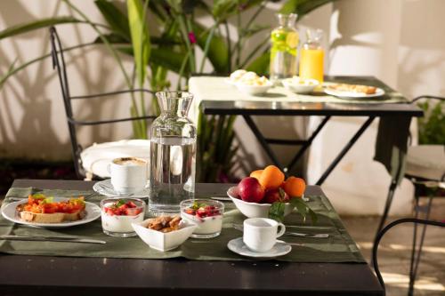 a table with a tray of food on it with cups and bowls of fruit at Don Alfonso Dimora D'epoca in Racale