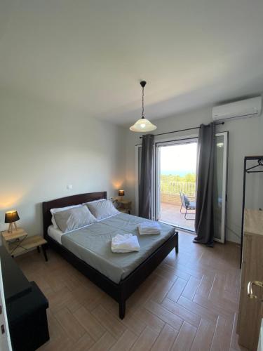 a bedroom with a bed and a sliding glass door at Sea View House in Astrakeri