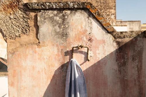 an umbrella hanging from a hook on a wall at Don Alfonso Dimora D'epoca in Racale