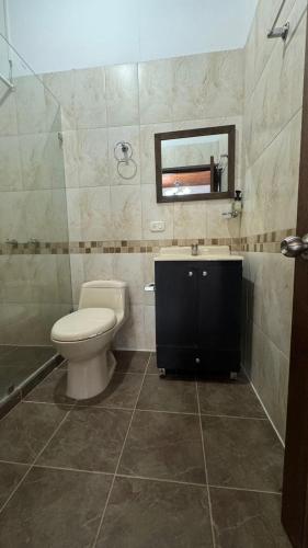 a bathroom with a toilet and a sink and a mirror at El Balcón de Emma in Jardin