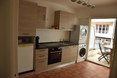 La cuisine est équipée d'une cuisinière, d'un évier et d'un lave-vaisselle. dans l'établissement Les Fleurs, à Antibes