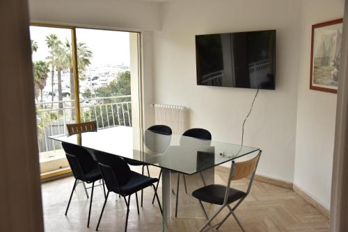 une salle à manger avec une table et des chaises en verre dans l'établissement Les Fleurs, à Antibes