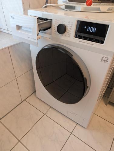 a white washing machine sitting on a kitchen floor at Helles Studio mit Arbeitsplatz und Balkon in Chemnitz
