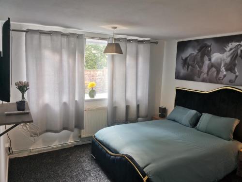 a bedroom with a bed and a window at Brendon Rooms Luton Airport in Luton