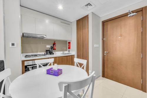 a kitchen and dining room with a white table and chairs at Wonderful Reva Aparthotel Downtown in Dubai