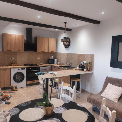 une cuisine et un salon avec une table et un canapé dans l'établissement Bastidon, à La Celle-sous-Gouzon