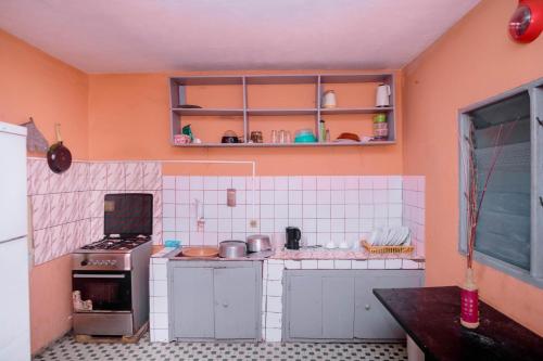 een kleine keuken met een fornuis en een aantal kasten bij Crystal Home in Douala